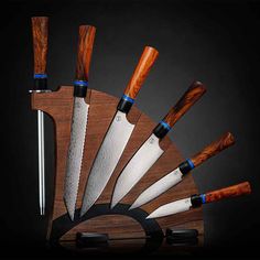 several knives are arranged in a fan shape on a wooden stand with blue trimmings