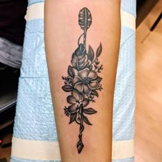 a black and white flower tattoo on the arm