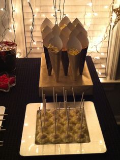 desserts are displayed on plates in front of a window with christmas lights behind them