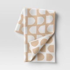 a beige and white patterned napkin on top of a table