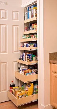 an open pantry door in a kitchen with food on the shelves and other items inside