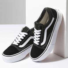 a pair of black and white vans shoes