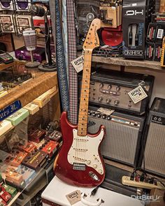 an electric guitar and amps are on display in a music store with other musical instruments