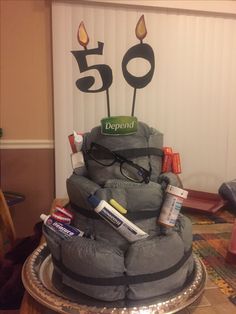 a birthday cake made to look like a pile of stuff with candles and eyeglasses on top