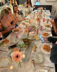 a group of people sitting at a table with plates of food in front of them