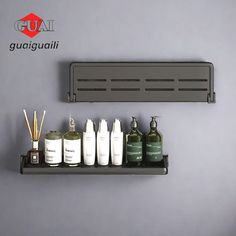 a shelf that has some bottles and soaps on it next to a wall mounted mirror