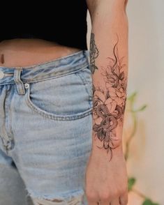 a woman with a flower tattoo on her left arm and right hand is holding onto the other side of her waist