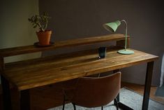 a wooden desk with a lamp and chair