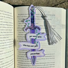 an open book with some stickers attached to it's pages and a tassel