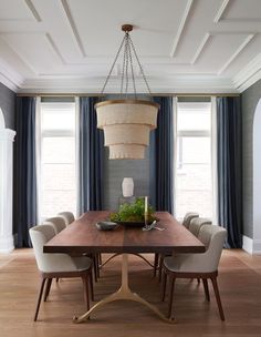 a dining room table with chairs and a chandelier hanging from the ceiling