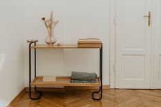 a wooden table sitting on top of a hard wood floor next to a white door