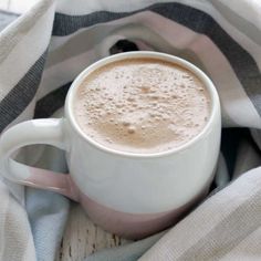 a cup of hot chocolate sitting on top of a blanket