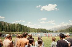 a group of people standing in front of a lake