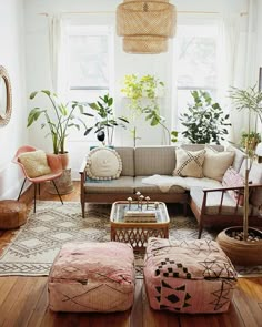 a living room filled with lots of furniture and plants