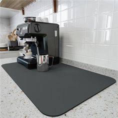 a coffee machine sitting on top of a kitchen counter next to a cup and saucer