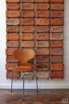 a wooden chair sitting in front of a stack of boxes with words on the wall