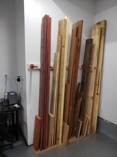 several pieces of wood stacked on top of each other next to a white wall in an office