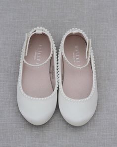 two pairs of white shoes with pearls on the bottom and one pair is in full view