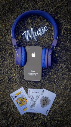 the headphones are next to an ipod and some cards on the ground with music written on them