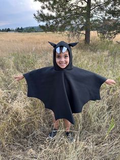 🦇 Fleece Bat Cape for Kids - Vampire Bat Costume with Hood, Ears, and Fangs 🦇 Let your little one take flight in our cozy, black fleece Bat Cape! 🖤 Perfect for Halloween, dress-up days, or imaginative play, this costume will make your child feel like a real vampire bat. ️ Crafted from soft, durable fleece, this cape is designed for comfort and ease. The pullover style allows for quick and hassle-free dressing, making it perfect for kids on the go. 🧒 The attached hood features charming vampir Diy Bat Costume Kids, Diy Kids Costumes For Boys, Bat Costume Diy, Bat Costume Kids, Bat Fancy Dress, Toddler Bat Costume, Vampire Bat Costume, Kids Bat Costume, Diy Bat Costume