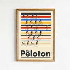 the peloton cycling poster is hanging in a wooden frame against a white wall