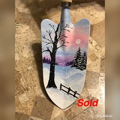 a hand painted snowboard with a tree and fence in the foreground is sold