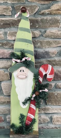 a wooden sign with a santa clause and candy canes on it's side