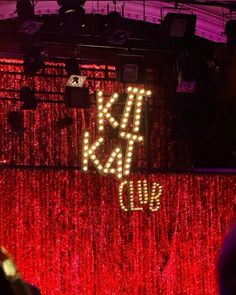 a red curtain with lights that say kiss and dub on it in front of a stage