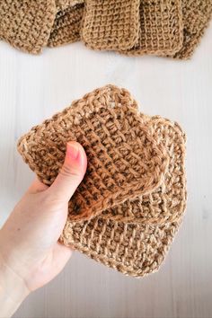 someone is holding their hand over the top of some crocheted hats