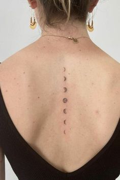 the back of a woman's neck with her sun and moon tattoos on it