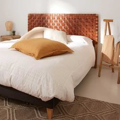 a bed with white sheets and brown pillows