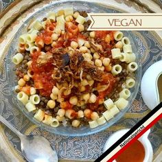 a bowl filled with pasta and sauce on top of a plate