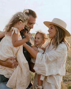 a man, woman and child are standing in the grass with their arms around each other