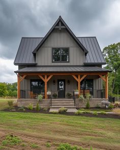 a large gray house sitting on top of a lush green field