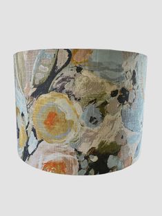 a lampshade with an abstract floral design on the fabric, and light blue background