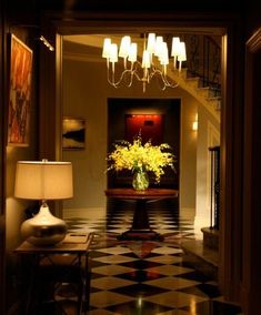 a vase with yellow flowers sitting on top of a black and white checkered floor