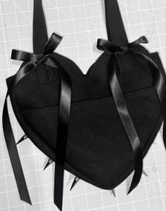 a heart shaped bag with black ribbon tied around the edges and two bows on each side