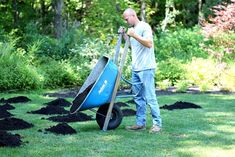 a man pushing a wheelbarrow filled with dirt