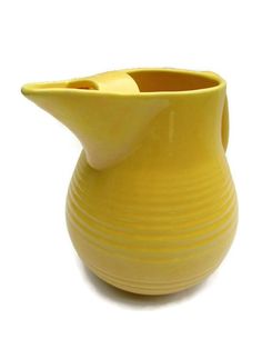 a yellow vase sitting on top of a white table