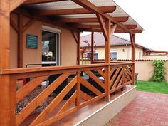 a wooden porch with an awning over it and brick walkway leading to the front door