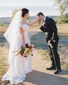 a bride and groom standing together in the desert