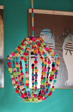 a multicolored beaded light hanging from a ceiling in a room with pictures on the wall