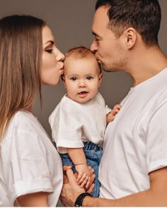 a man and woman kissing their baby boy