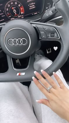 a woman's hand on the steering wheel of a car