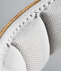 close up view of the inside of a white and gold shoe with laces on it