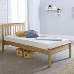 a wooden bed frame sitting on top of a carpeted floor next to a window