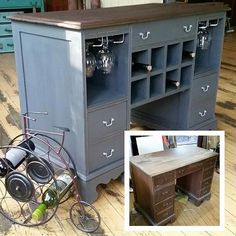 an old desk with wine glasses on it and a bike leaning against the top shelf