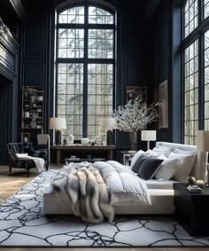 an elegant bedroom with black walls and white bedding, large windows, fur rugs on the floor