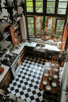 an old fashioned kitchen with black and white checkerboard flooring, wooden cabinetry, and windows