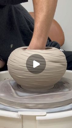 a man is making a vase out of clay